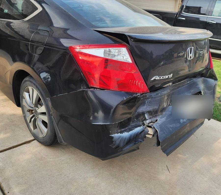 Black Honda Accord coupe with a torn and crushed rear bumper, before repair