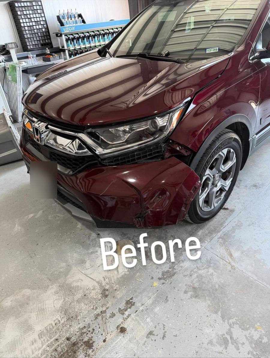 Burgundy Honda CR-V in the shop with a damaged front bumper, before repair
