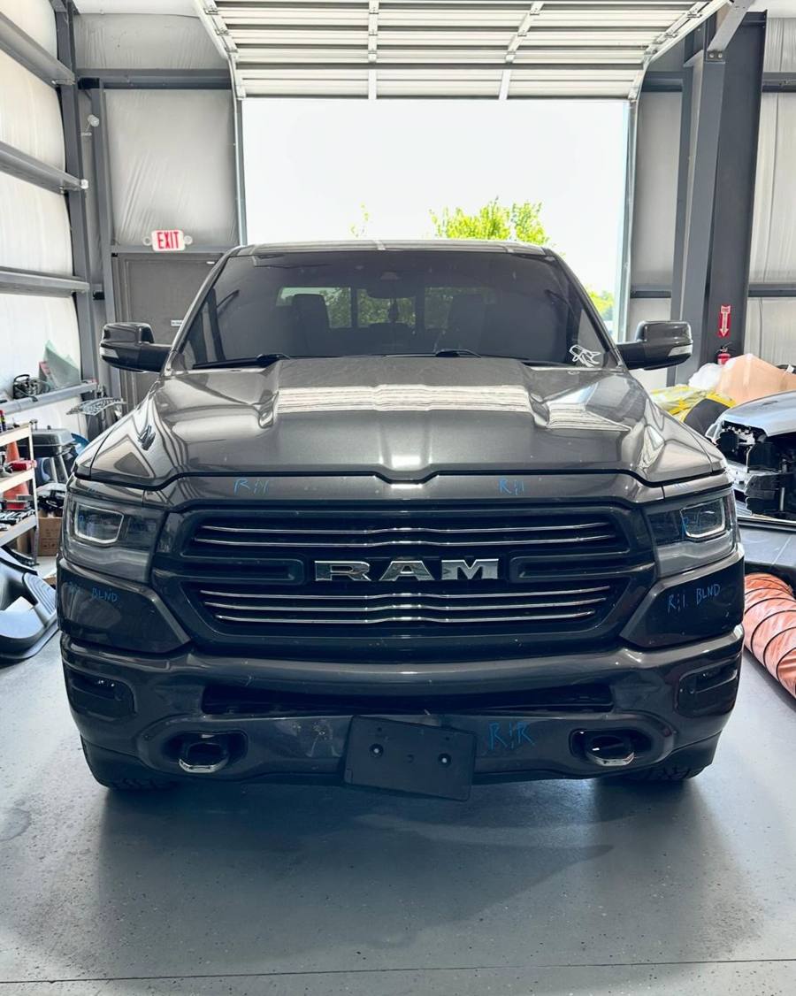 Front of the Ram 1500 with blue repair plan marks on the grille, headlights, and bumper